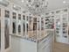 Custom walk-in closet with a beautiful stone island, glass cabinets, and shelving for clothing and accessories at 3799 Flamingo Ave, Sarasota, FL 34242