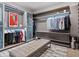 Modern walk-in closet features a bench, custom shelves and cabinets, rod hanging, and a unique modern rug at 3799 Flamingo Ave, Sarasota, FL 34242