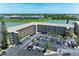 Aerial view showcasing condominium buildings, a parking lot, lush green landscaping, and a scenic lake at 3801 Lake Bayshore Dr # H413, Bradenton, FL 34205