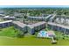 Stunning aerial of condo buildings, lush landscapes, lake, community fishing pier, and swimming pool at 3801 Lake Bayshore Dr # H413, Bradenton, FL 34205