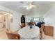 Bright dining room with a ceiling fan, light walls, and views of the living room and balcony at 3801 Lake Bayshore Dr # H413, Bradenton, FL 34205