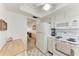 Compact kitchen with white cabinetry and appliances, and neutral flooring that flows into the dining area at 3801 Lake Bayshore Dr # H413, Bradenton, FL 34205