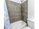 Bathroom with a shower-tub combo featuring light gray tiling and fixtures, creating a relaxing and functional space at 4116 43Rd W Ave, Bradenton, FL 34205