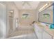 Bright bathroom featuring dual sinks, large tub under arched window and walk-in shower with glass door at 4137 Woodview Dr, Sarasota, FL 34232