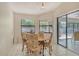 Cozy breakfast area features garden views through large windows and a glass sliding doors for patio access at 4137 Woodview Dr, Sarasota, FL 34232