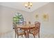 Bright dining room with decorative table, patterned chairs, arched window and green leafy plants art at 4137 Woodview Dr, Sarasota, FL 34232