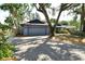 Paver driveway leading to a two-car garage, surrounded by mature trees and landscaping for added curb appeal at 4137 Woodview Dr, Sarasota, FL 34232