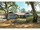 Charming single-story home featuring a well-manicured front lawn with mature trees at 4137 Woodview Dr, Sarasota, FL 34232
