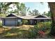 Charming one-story home featuring a well-manicured front yard, blue siding, and an attached two-car garage at 4137 Woodview Dr, Sarasota, FL 34232