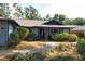 Charming home with a beautiful front garden, a brick walkway, a covered entry, and attractive blue and gray accents at 4137 Woodview Dr, Sarasota, FL 34232