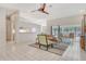 Open living room features tile floors, a ceiling fan, and seamless access to the kitchen and screened lanai at 4137 Woodview Dr, Sarasota, FL 34232