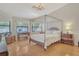 Bright main bedroom with four poster bed, wood floors, chandelier, desk, and dresser at 4137 Woodview Dr, Sarasota, FL 34232