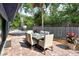 A brick-paved patio features an outdoor dining area adjacent to the house, with lush landscaping at 4137 Woodview Dr, Sarasota, FL 34232