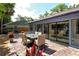 A brick-paved patio features an outdoor dining area adjacent to the house, with lush landscaping at 4137 Woodview Dr, Sarasota, FL 34232