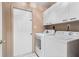 Laundry room featuring a modern washer and dryer, tile floors and overhead cabinets for ample storage at 4222 Lanai Dr, Sarasota, FL 34241