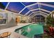 Night view of a screened-in pool and spa with outdoor seating area, landscape lighting and water feature at 4222 Lanai Dr, Sarasota, FL 34241