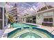 Relaxing screened-in pool and spa with patio, ceiling fans and outdoor furniture perfect for entertaining at 4222 Lanai Dr, Sarasota, FL 34241