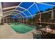 Evening view of a screened-in pool and spa with outdoor seating area and stylish landscaping at 4222 Lanai Dr, Sarasota, FL 34241