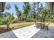 Stone patio with table and chairs overlooks a serene, private backyard at 435 Whispering Oaks Ct, Sarasota, FL 34232