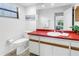 Bathroom featuring accent countertop, white cabinets, and a large mirror at 435 Whispering Oaks Ct, Sarasota, FL 34232
