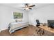 Well-lit bedroom with hardwood floors, a ceiling fan, a desk, and ample natural light at 435 Whispering Oaks Ct, Sarasota, FL 34232