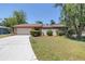 Charming single-story home featuring a stone facade, well-manicured lawn, and inviting curb appeal at 435 Whispering Oaks Ct, Sarasota, FL 34232