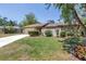 Charming home exterior with stone accents and a well-manicured front lawn at 435 Whispering Oaks Ct, Sarasota, FL 34232