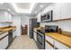 Modern kitchen featuring stainless steel appliances, light countertops, and ample cabinet space at 435 Whispering Oaks Ct, Sarasota, FL 34232