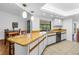 Well-lit kitchen with wood countertops, white cabinetry, tile flooring and breakfast bar seating at 435 Whispering Oaks Ct, Sarasota, FL 34232