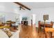 Bright living room with wood beam, ceiling fan, hardwood floors, white walls, and access to the dining area at 435 Whispering Oaks Ct, Sarasota, FL 34232