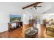 Open-concept living room featuring hardwood floors, a ceiling fan, and views of the connected dining and kitchen areas at 435 Whispering Oaks Ct, Sarasota, FL 34232