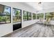 Light-filled sunroom with vinyl flooring and multiple windows overlooking the lush backyard at 435 Whispering Oaks Ct, Sarasota, FL 34232