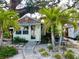 Quaint cottage with palm trees, stone walkway, and a cozy, inviting front yard at 4412 125Th W St, Cortez, FL 34215