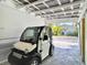 Charming electric vehicle parked inside the covered garage with view of the cozy home at 4412 125Th W St, Cortez, FL 34215