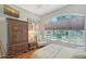 Comfortable bedroom with a large window, cozy chair, and classic wooden furniture at 4603 4Th E Ave, Bradenton, FL 34208