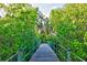Scenic wooden bridge on nature trail surrounded by lush mangrove trees and a serene waterway at 4603 4Th E Ave, Bradenton, FL 34208