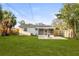 Expansive yard features a well-kept lawn, mature trees, and screened-in patio at 5045 10Th S Ave, Gulfport, FL 33707