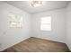 Sunlit bedroom with wood-look flooring, crisp white walls, and a contemporary light fixture at 5045 10Th S Ave, Gulfport, FL 33707