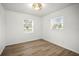 Bright bedroom featuring two windows, modern light fixture, and wood-look flooring at 5045 10Th S Ave, Gulfport, FL 33707