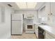 Practical kitchen with white cabinetry and appliances, tile flooring, and ample lighting for everyday cooking needs at 5062 White Oak Ct, Bradenton, FL 34207