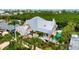Aerial view of a charming home with a metal roof, pool, and lush tropical landscaping and a bayou in the background at 512 77Th St, Holmes Beach, FL 34217