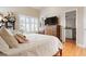 Bright bedroom features hardwood floors, plantation shutters, and ensuite bathroom access at 512 77Th St, Holmes Beach, FL 34217