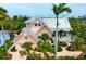Charming two-story home featuring a metal roof, a two-car garage, and lush tropical landscaping at 512 77Th St, Holmes Beach, FL 34217