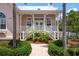 Charming pink home featuring manicured landscaping, white trim, and inviting front porch at 512 77Th St, Holmes Beach, FL 34217