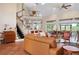 Spacious living room showcasing high ceilings, brick fireplace, and large windows overlooking lush greenery at 512 77Th St, Holmes Beach, FL 34217