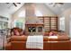 Cozy living room featuring a brick fireplace, high ceilings, large windows, and comfortable leather seating at 512 77Th St, Holmes Beach, FL 34217