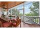 Screened-in porch featuring a wood dining table, seating for eight, and scenic views of the surrounding landscape at 512 77Th St, Holmes Beach, FL 34217
