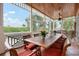 Covered porch featuring a dining table with seating for ten, creating an ideal space for outdoor gatherings at 512 77Th St, Holmes Beach, FL 34217