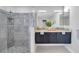 Bathroom featuring a walk-in shower with decorative tile and a double sink vanity at 5125 Palm Aire Dr, Sarasota, FL 34243
