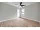 A simple bedroom with light wood floors, a ceiling fan and a door to the exterior at 5125 Palm Aire Dr, Sarasota, FL 34243